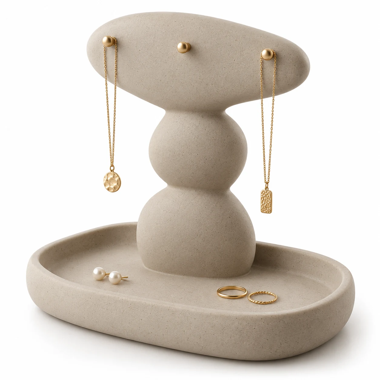 KELIKULI Pebble Stack sculptural resin jewelry organizer with three gold-tone pegs and integrated vanity tray, styled with necklaces, pearl earrings and rings on a white background.